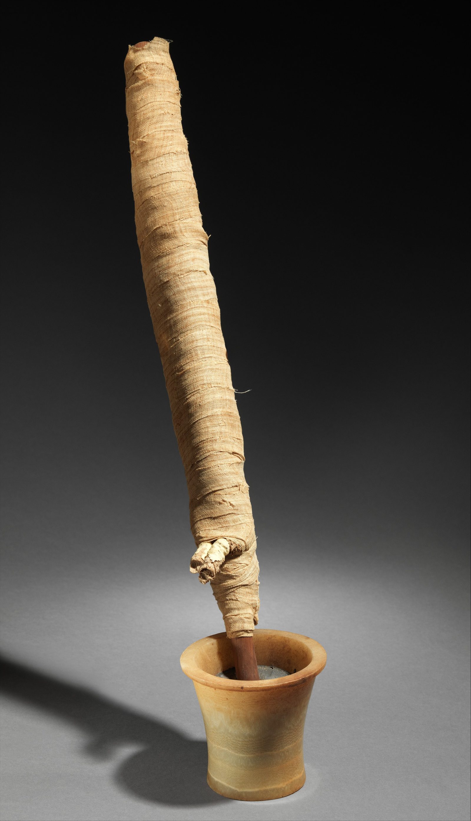 A Middle Kingdom imiut fetish carved from travertine (Egyptian alabaster) and cedar, dated to the reign of Amenemhat II around 1919 to 1885 BC, recovered from excavations at Lisht and now in the Metropolitan Museum of Art.