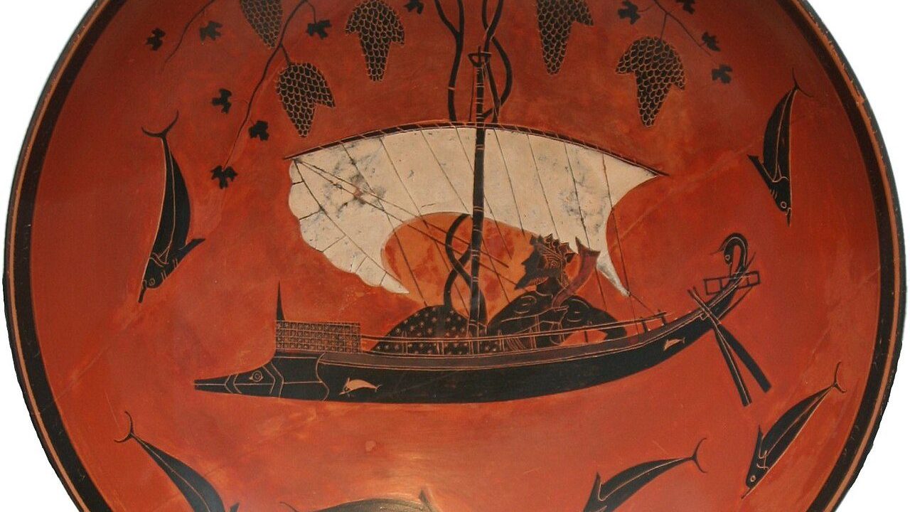 The interior of a black-figure kylix by the vase painter Exekias, circa 530 BC, showing Dionysus reclining in a sailboat whose mast has become a grapevine heavy with clusters of grapes, surrounded by leaping dolphins.