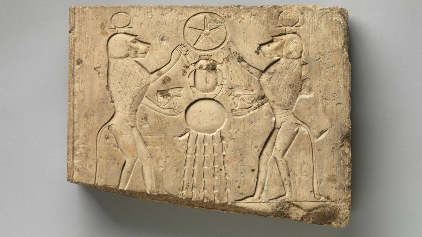 Ancient Egyptian relief panel, Late Period to Ptolemaic Period, showing two baboons offering the wedjat eye to the sun god Khepri, who holds the hieroglyphic sign for the underworld.