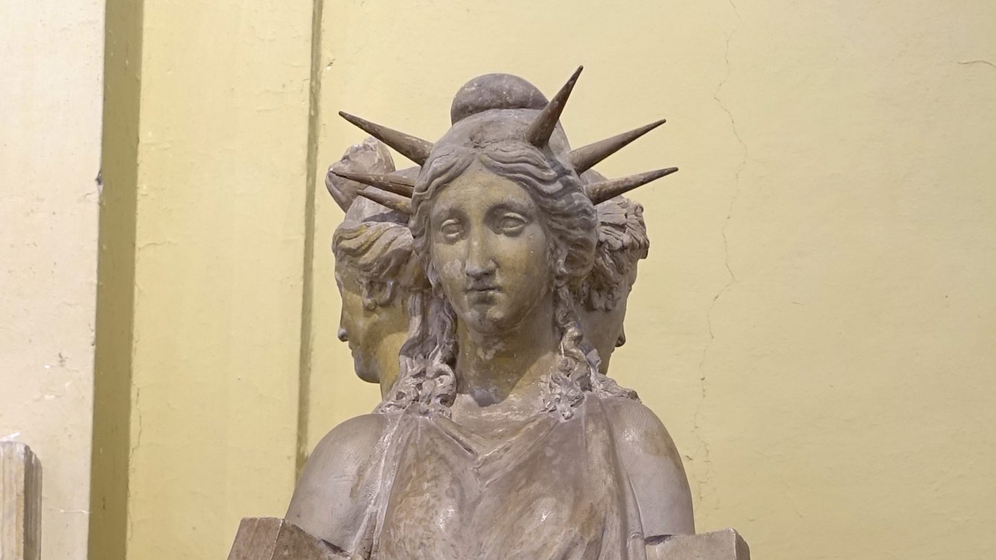 Close-up of the triple-formed statue of Hecate, a Roman marble copy after a Hellenistic original, showing the crowned central face and the two other faces of the three-headed figure. Now in the Museo Chiaramonti, Vatican Museums.