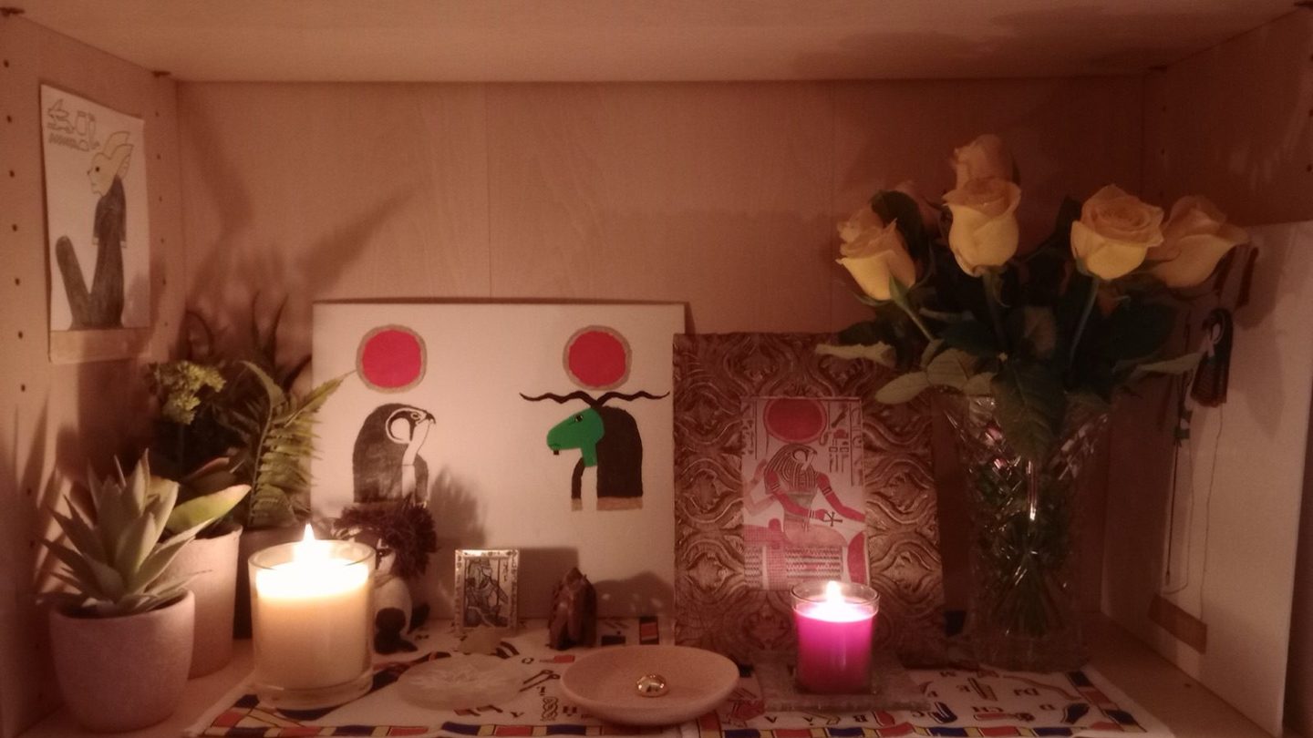 A modern private Kemetic altar with a statue and an incense offering dedicated to the god Horus, photographed in 2023.