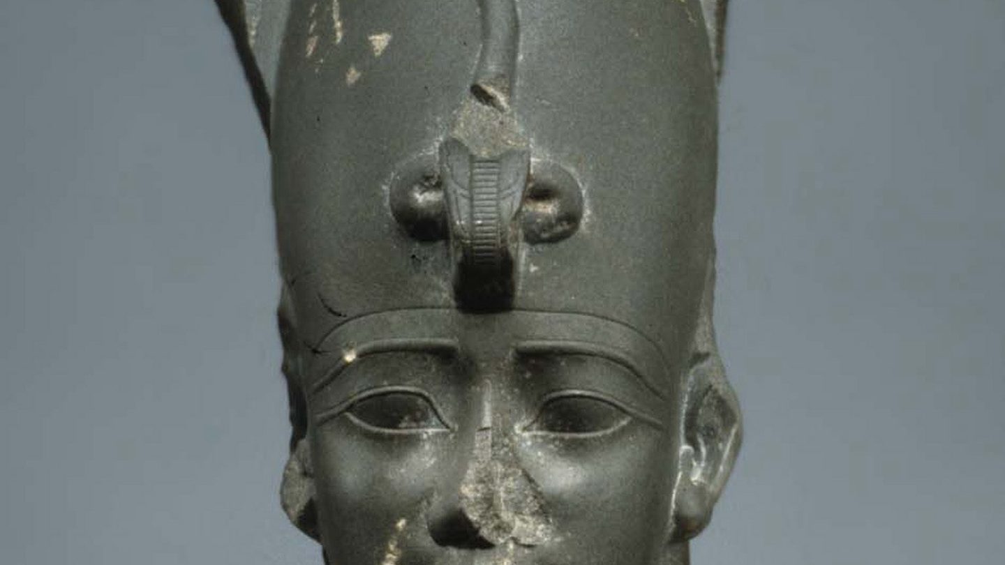A sculpted head of Osiris wearing the Atef crown, the white Hedjet crown of Upper Egypt flanked by two curled ostrich feathers, from the Metropolitan Museum of Art's collection.