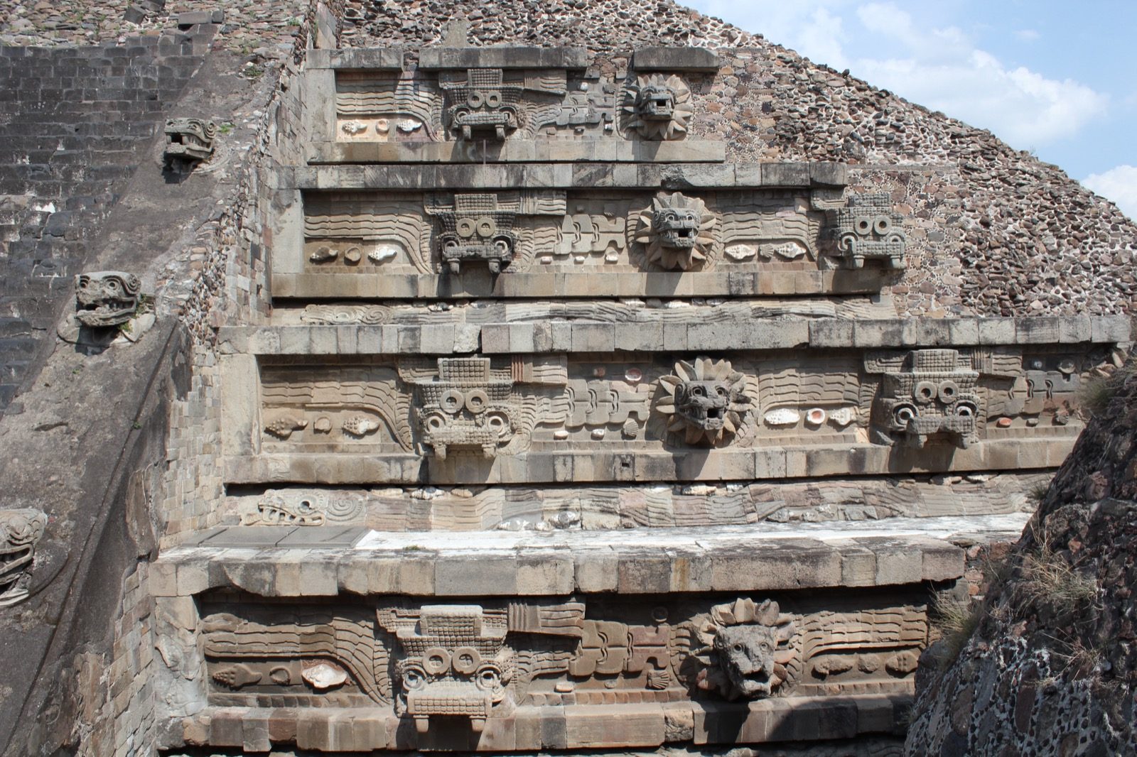 The Temple of the Feathered Serpent at Teotihuacan, a six-level step pyramid with carved serpent heads projecting from its facade, photographed in 2015.