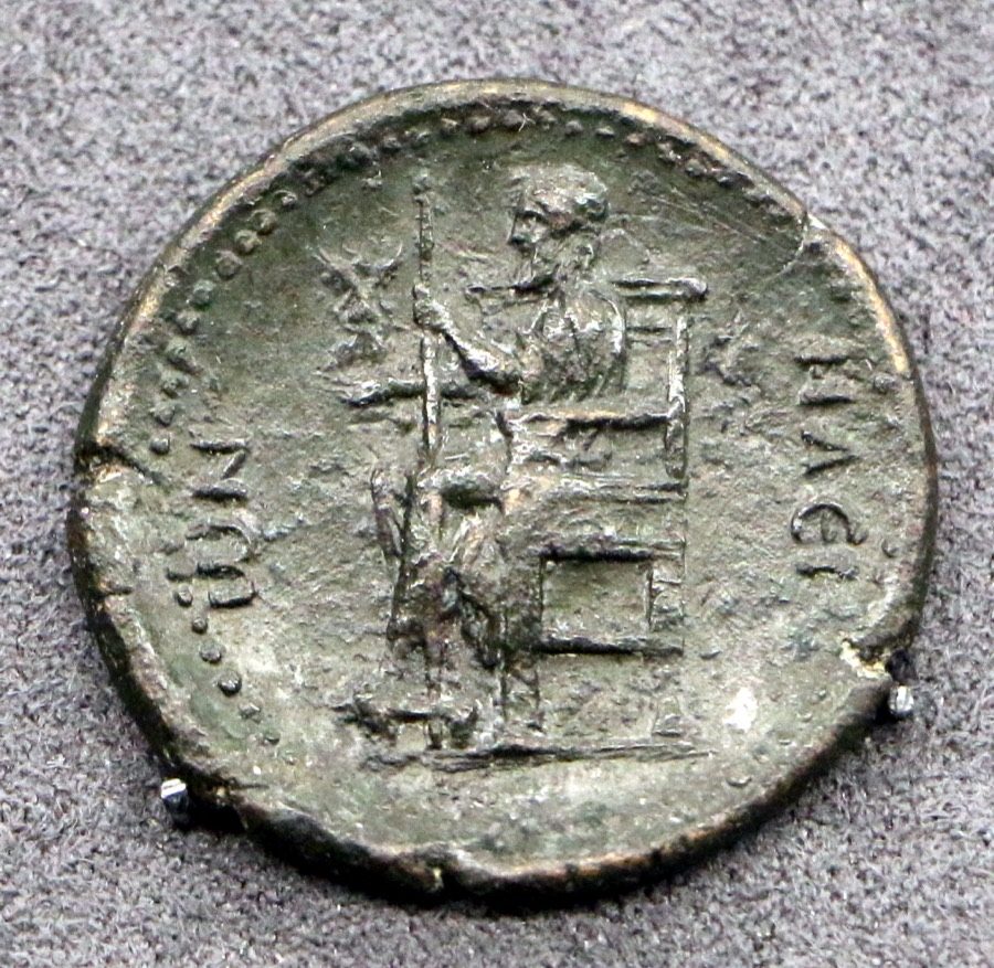Bronze coin struck at Elis under the Roman emperor Hadrian, showing the Olympian Zeus seated on his throne with a long scepter and a small figure held out in his other hand. Coins like this were minted while the statue still stood, but at coin scale and heavily stylized; no full-size copy or drawing made from the original survives.